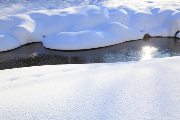 一条被白雪覆盖的地面环绕的水流 — 图库照片