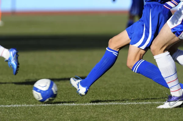 草の上のサッカーをするスポーツの人々の足 — ストック写真