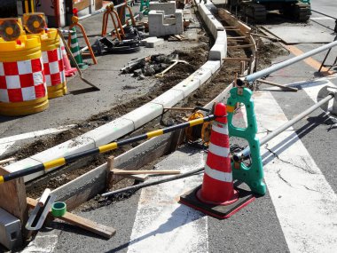 İnşaat alanı, yol çalışması bariyerleri ve ekipmanları gösteriyor.