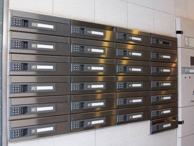 Metalik posta kutuları içerideki duvarlar boyunca düzgünce dizilmiş.