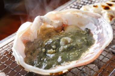 Sıcak kömürün üzerinde taze deniz ürünleri kızartıyorum.