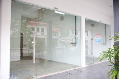 Büyük cam pencere ve kapıların yer aldığı boş depo önü