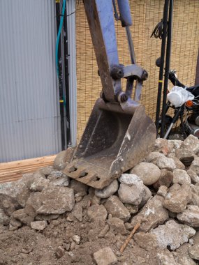 Kazı kovası büyük kaya yığınlarını kazıyor.