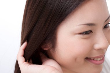 Beyaz arka planda gülümseyen Asyalı kadın. 