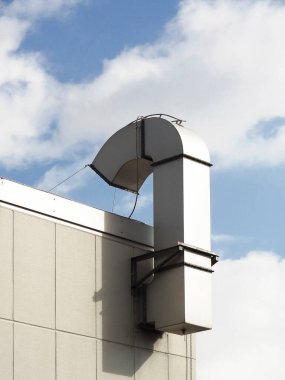 Modern binanın çatısına uzanan büyük endüstriyel havalandırma kanalı.