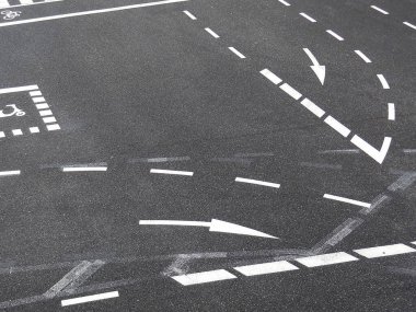 Yeni boyanmış beyaz yol işaretleri çoklu dönüş şeritlerini gösteriyor