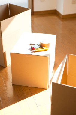 Boş odadaki karton kutudaki araçların yakın görüntüsü. yeni ev kavramı        