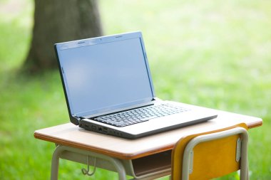 Laptopu yeşil alandaki açık masada kapat.