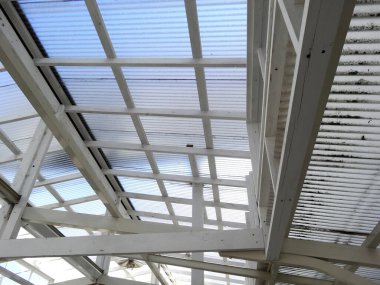 Beyaz ahşap kirişlere ve cam çatıya bakıyorum.