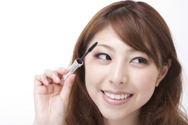 Genç Asyalı kadının yakın plan portresi. Arka planda ve güzellik rutiniyle.