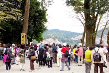 Gezen ve manzaranın tadını çıkaran insanlarla dolu bir Japon parkı. Kiraz çiçekleri de dahil..