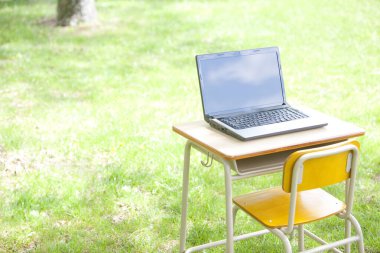 Laptopu yeşil alandaki açık masada kapat.