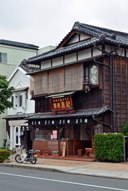 Tabela ve bisikletin park edildiği geleneksel ahşap bina.