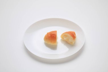 Beyaz tabakta iki parça çörek..