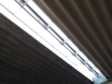 Floresan ışıkları endüstriyel tavan yapısını aydınlatıyor