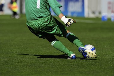 Spor giyim sektöründe futbol oyuncusunun bacakları çimlerin üzerinde top oynuyor.                 