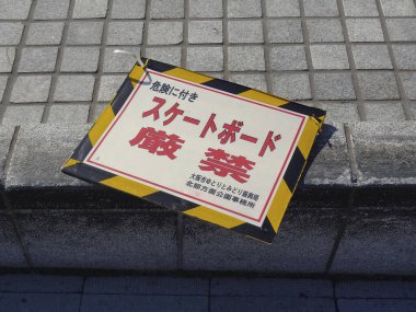 Japon metnini kaldırımın yanında gösteren uyarı levhası