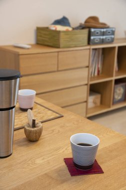 Kahve fincanı içerideki ahşap masada dinleniyor.