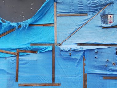 İnşaat alanındaki ahşap çerçeveleri kaplayan mavi brandalar.