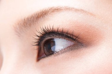 Güzellik kirpikleri makyajlı Asyalı genç bir kadının yakın plan fotoğrafı.