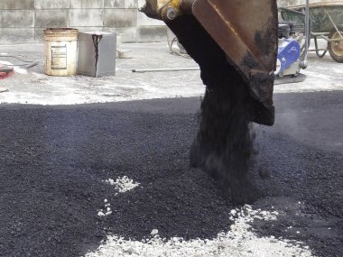 İnşaat alanının yüzeyine sıcak asfalt dökülüyor.