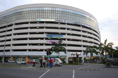 Palmiye ağaçları olan büyük kıvrımlı otopark binası