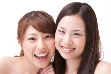 Beyaz arka planda gülümseyen genç Asyalı kadınlar 