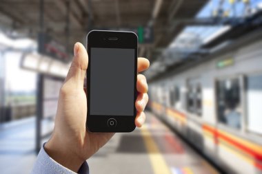 Kentsel arka planda boş ekranlı akıllı telefonu tutan kişinin kırpılmış görüntüsü