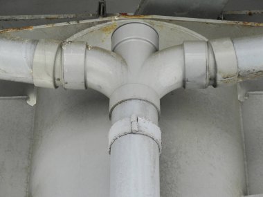 Kavşakta endüstriyel metal boruların bağlandığını gösteren yakın plan.