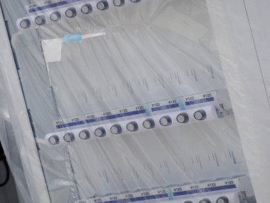 Koruyucu plastik ambalajlarla kaplı boş şeffaf rafları gösteren yakın plan.