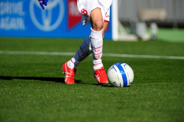 Spor giyim sektöründe futbol oyuncusunun bacakları çimlerin üzerinde top oynuyor.                 