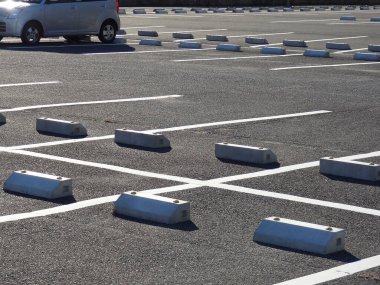 Boş otopark boyalı çizgiler ve beton bariyerler gösteriyor