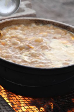 Metal tencerede ateşte pişen yemeğin yakın çekimi    