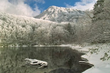 Kışın göl, karla kaplı dağlar.
