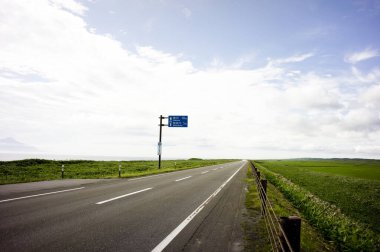 Yeşil çimenli ve mavi gökyüzü olan yol