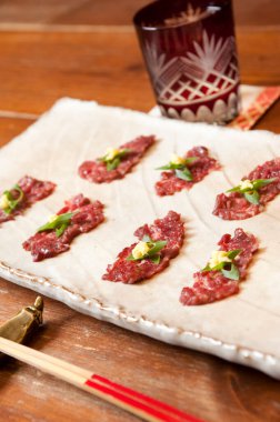 Canlı bir restoran ortamında taze otlar ve baharatlarla süslenmiş lezzetli etli tart tabağı.