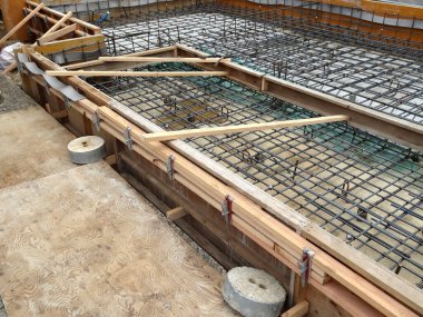 İnşaat alanındaki ahşap işçiliğin içinde düzenlenmiş çelik parmaklıkların güçlendirilmesi