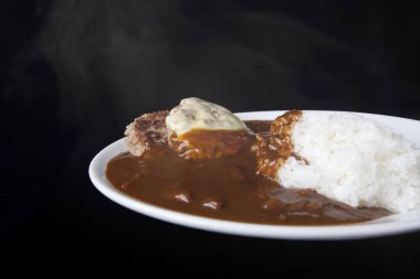 Köri soslu, pirzola ve haşlanmış pirinçli bir mutfak fotoğrafı. 