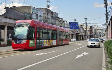 Modern şehir Japonya 'da gündüz tramvayı sokak sokak geziyor.