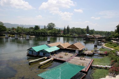 Mavi gökyüzünün altında durgun nehir kenarında yüzen evler
