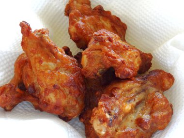 Beyaz bir plaka üzerinde pişmiş tavuk kanatları