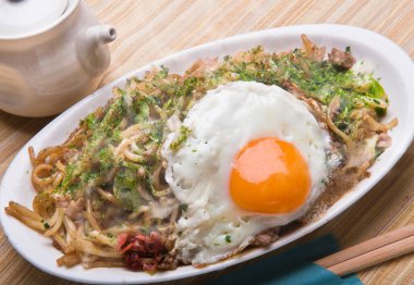 Kızarmış yumurta soslu erişte, sebze ve et.