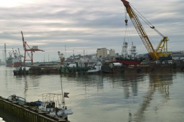 Büyük endüstriyel vinçler limandaki limandaki gemilerin yakınındaki kargoyu taşıyorlar.