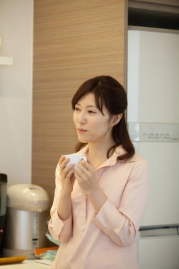 Asyalı kadın mutfakta kahve içme