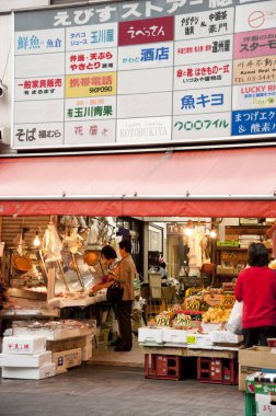 İnsanlar kalabalık Japon sokak tezgahından alışveriş yapıyor.