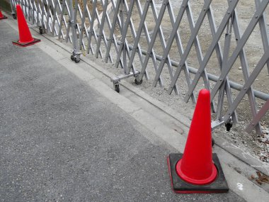 Kırmızı trafik konileri kaldırımda metal barikatın yanına yerleştirildi.