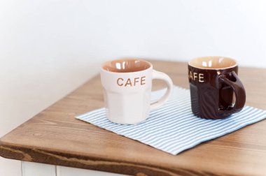 Tahta masadaki siyah ve beyaz bardakların yakın plan görüntüsü