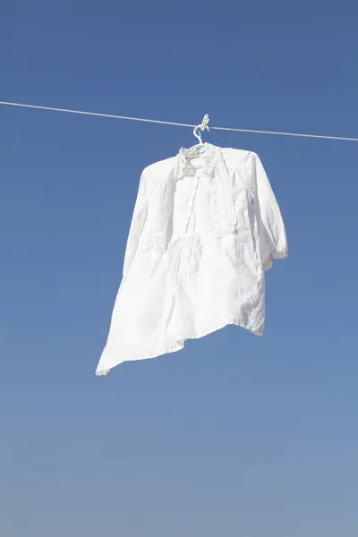 Biała Koszula Wisi Ponownie Niebieskie Niebo Tło — Zdjęcie stockowe