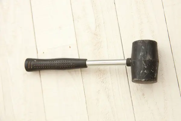 hammer with a handle tool, a wooden surface