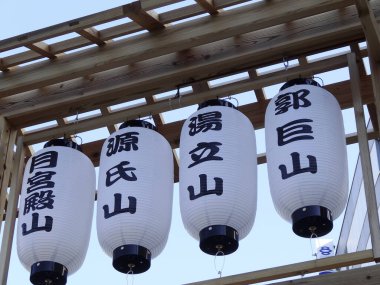 Beyaz Japon kağıt fenerleri ahşap yapının altında asılı.